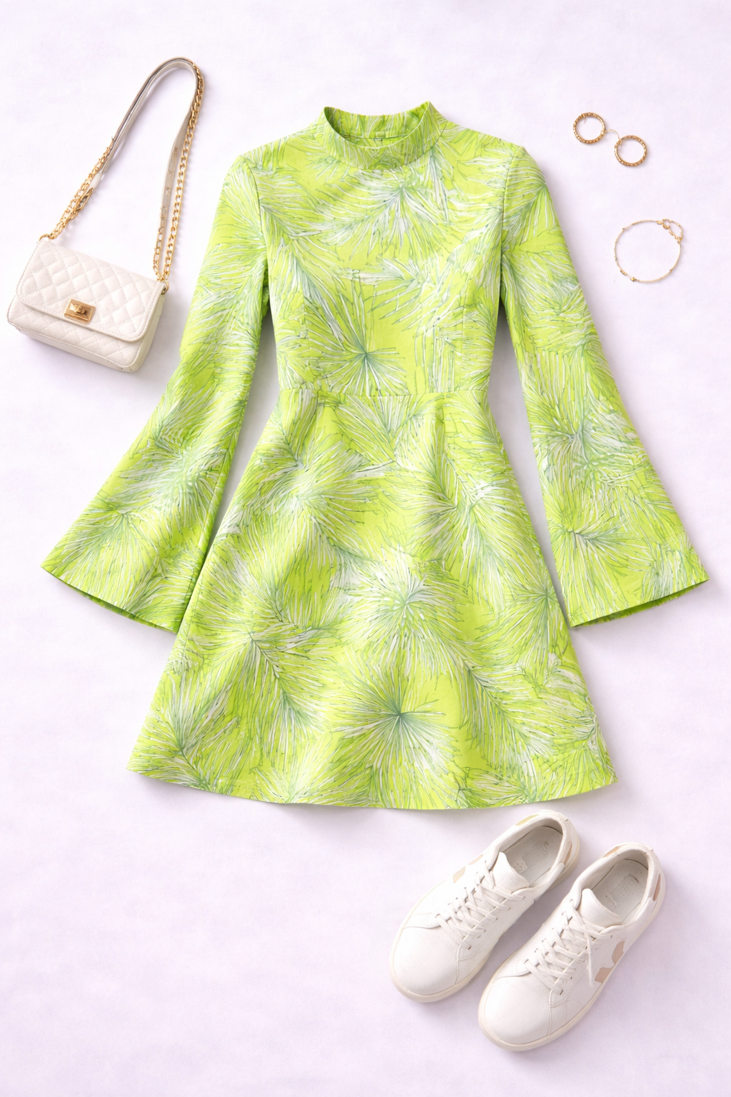 Green patterned dress with white sneakers, handbag, and jewelry on a light background