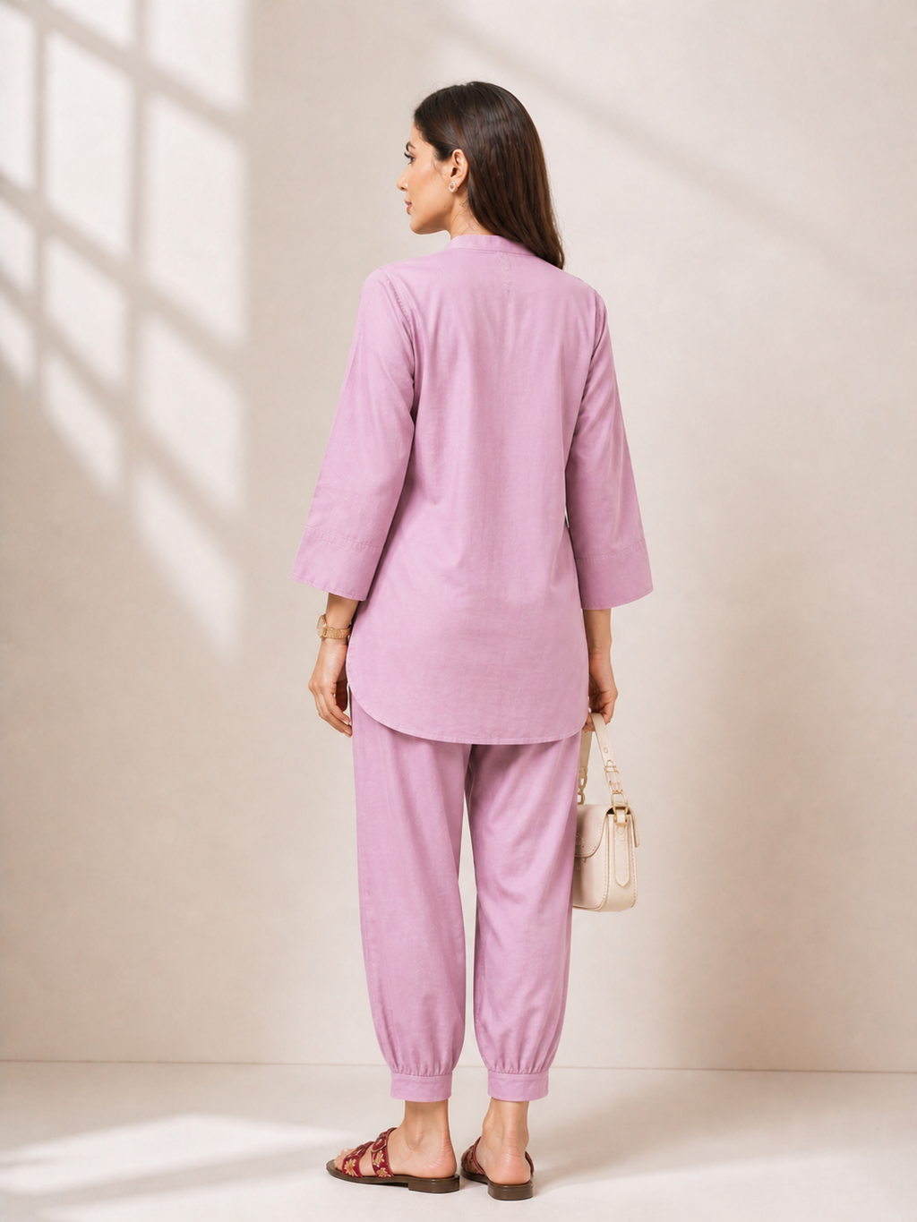 Woman wearing a lavender kurta set standing against a neutral background