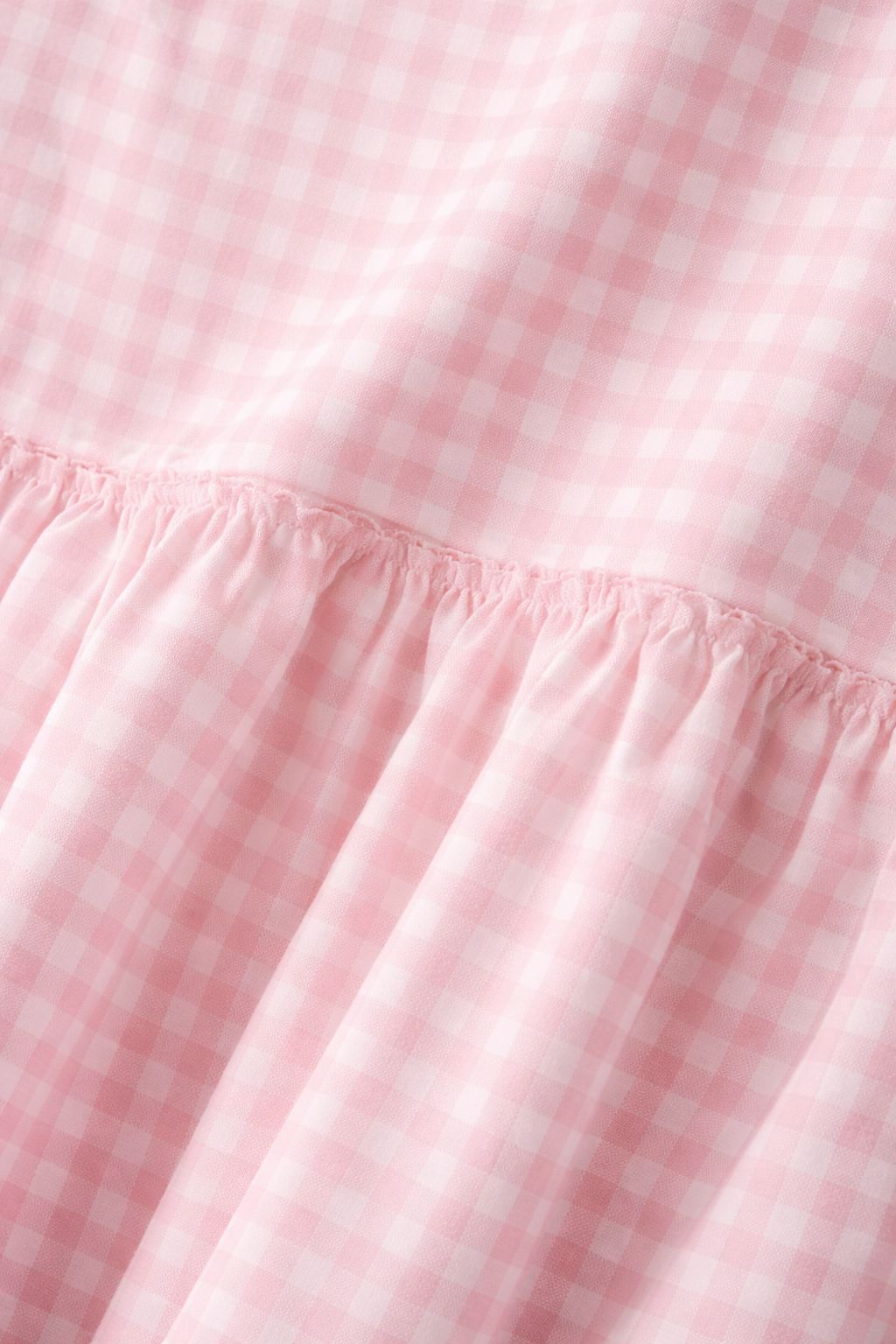 Close-up of pink gingham fabric on peplum coord set